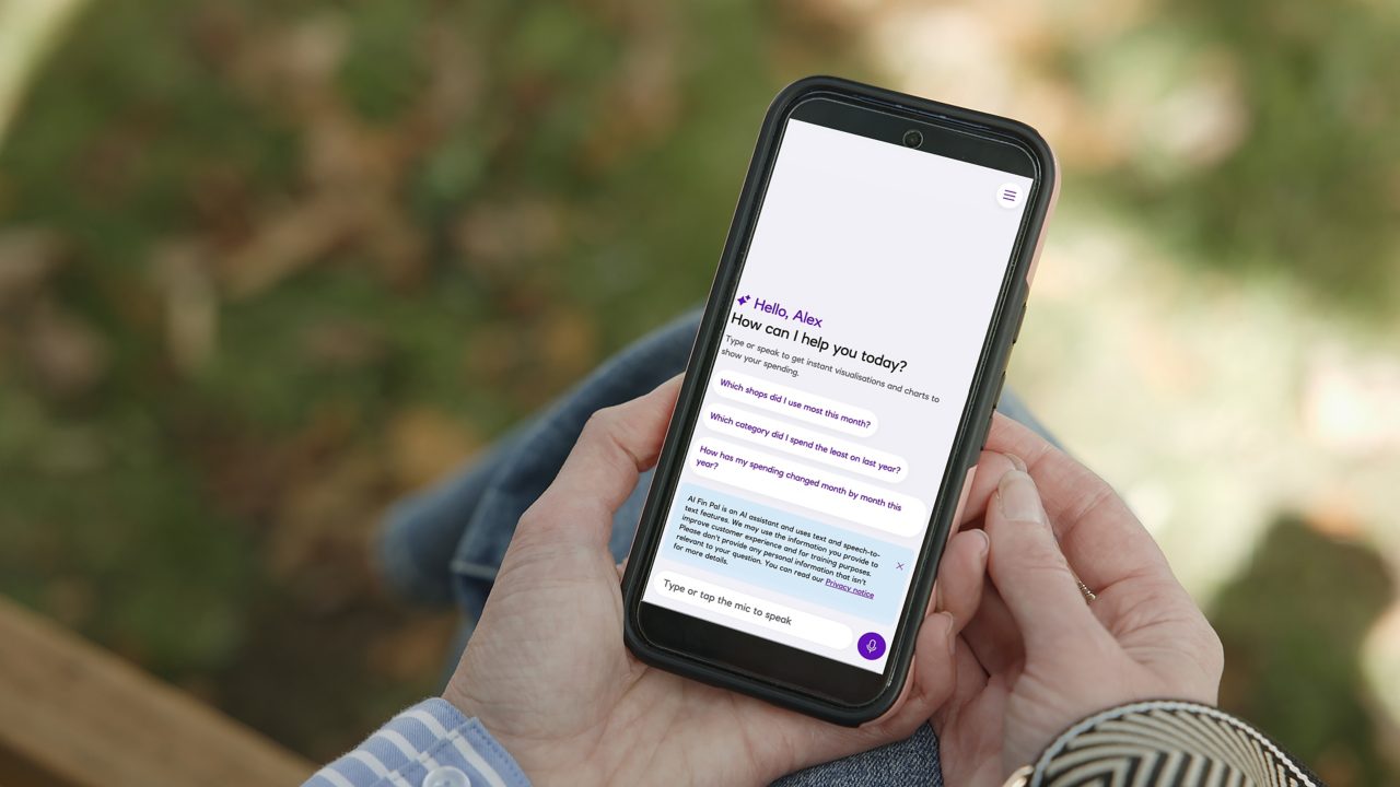 This image shows a person holding a mobile phone engaging with NatWest’s spending insights tool.