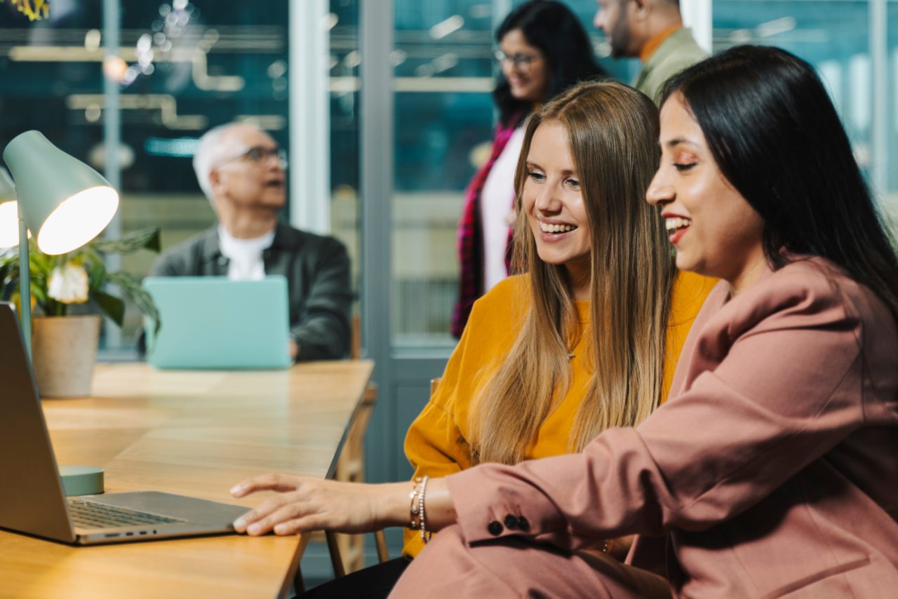 two female colleagues looking at a laptop