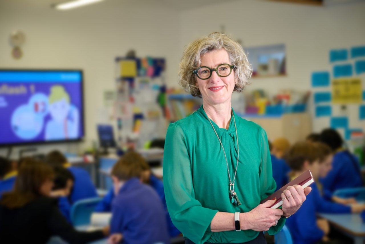 Lady in green top and glasses teaching a class