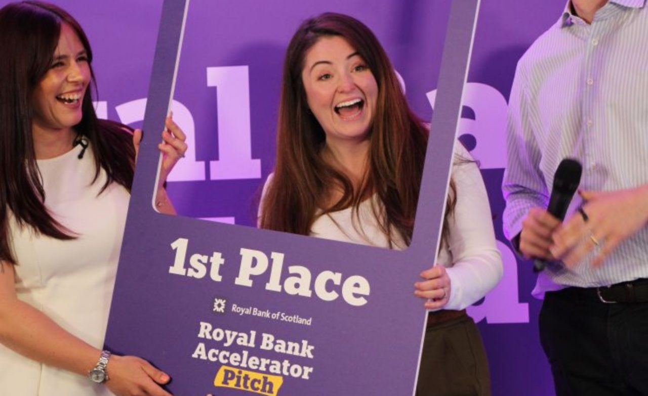 This image shows the founder of Padel posing on stage after winning the first ever Royal Bank Pitch competition at opening of new Edinburgh Accelerator Hub.
