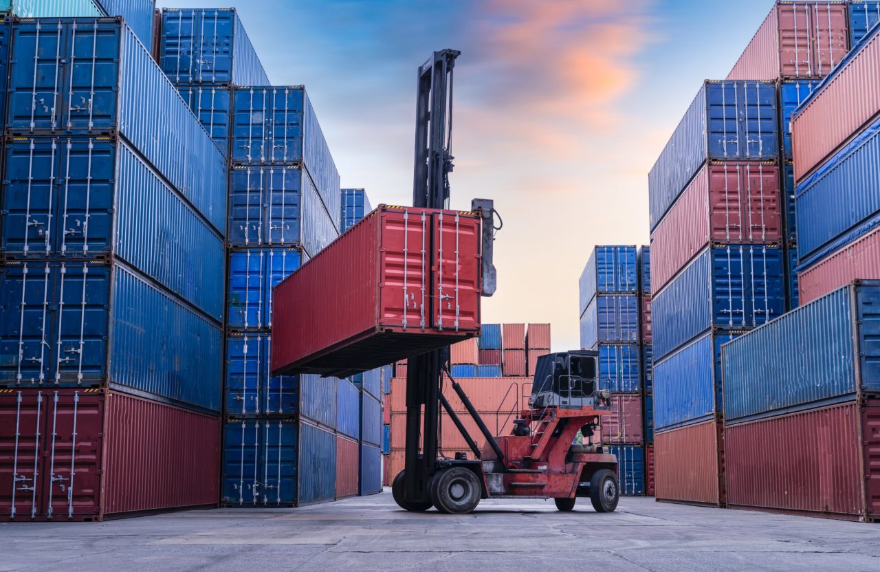 This image shows a forklift carrying a shipping container. 