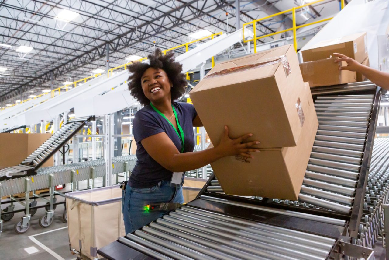 this image shows women standing at a production line in a factory setting