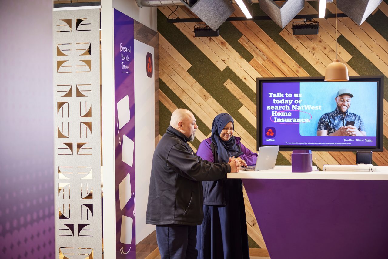 This image shows a male and female colleagues looking at a laptop together.