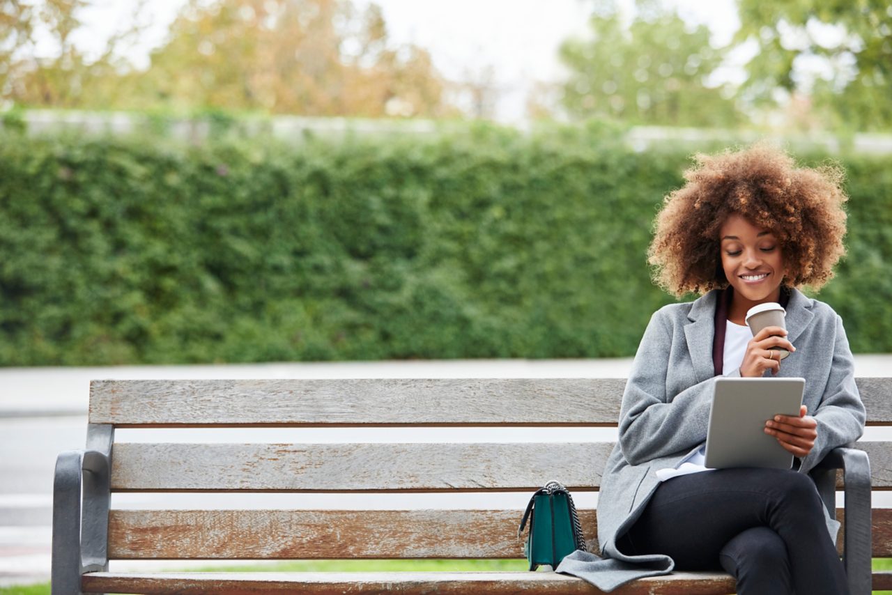 Woman sitting on bench drinking coffee