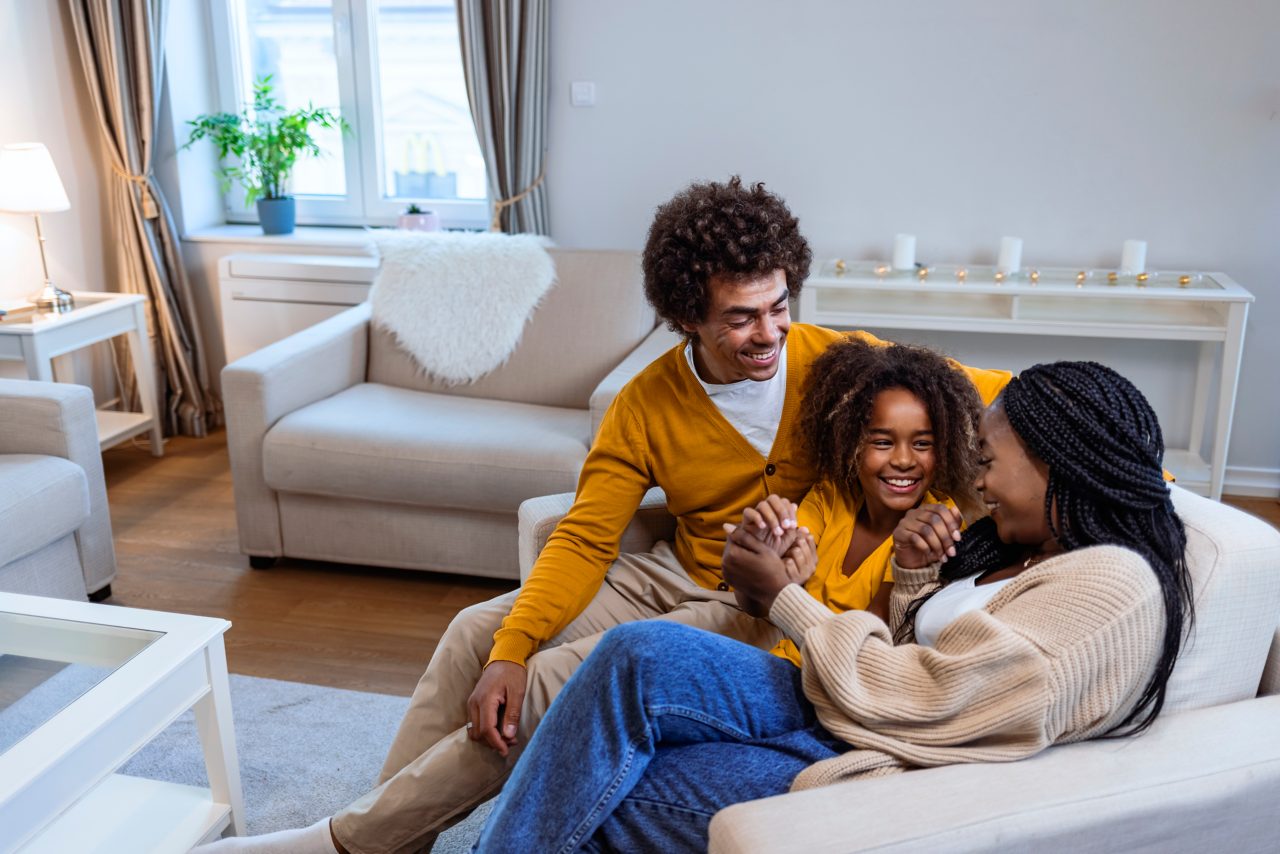 Family sitting on couch laughing